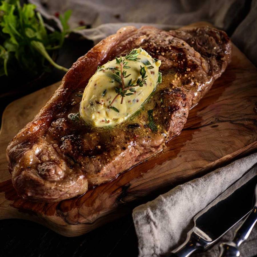 Pořádný steak připravený na grilu s bylinkovým máslem